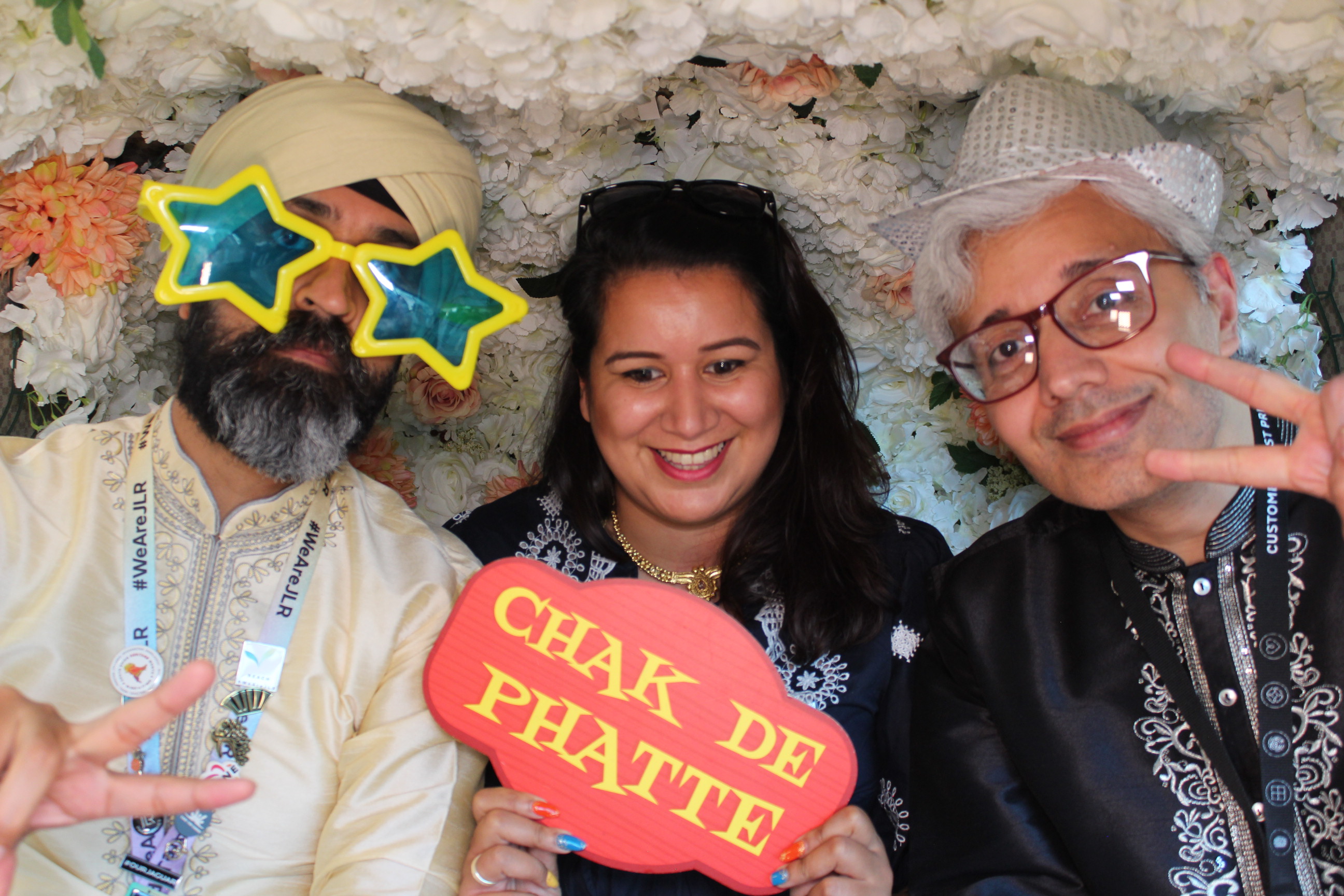 Friends wearing silly hats and sunglasses in a fun tuk tuk photobooth at an event